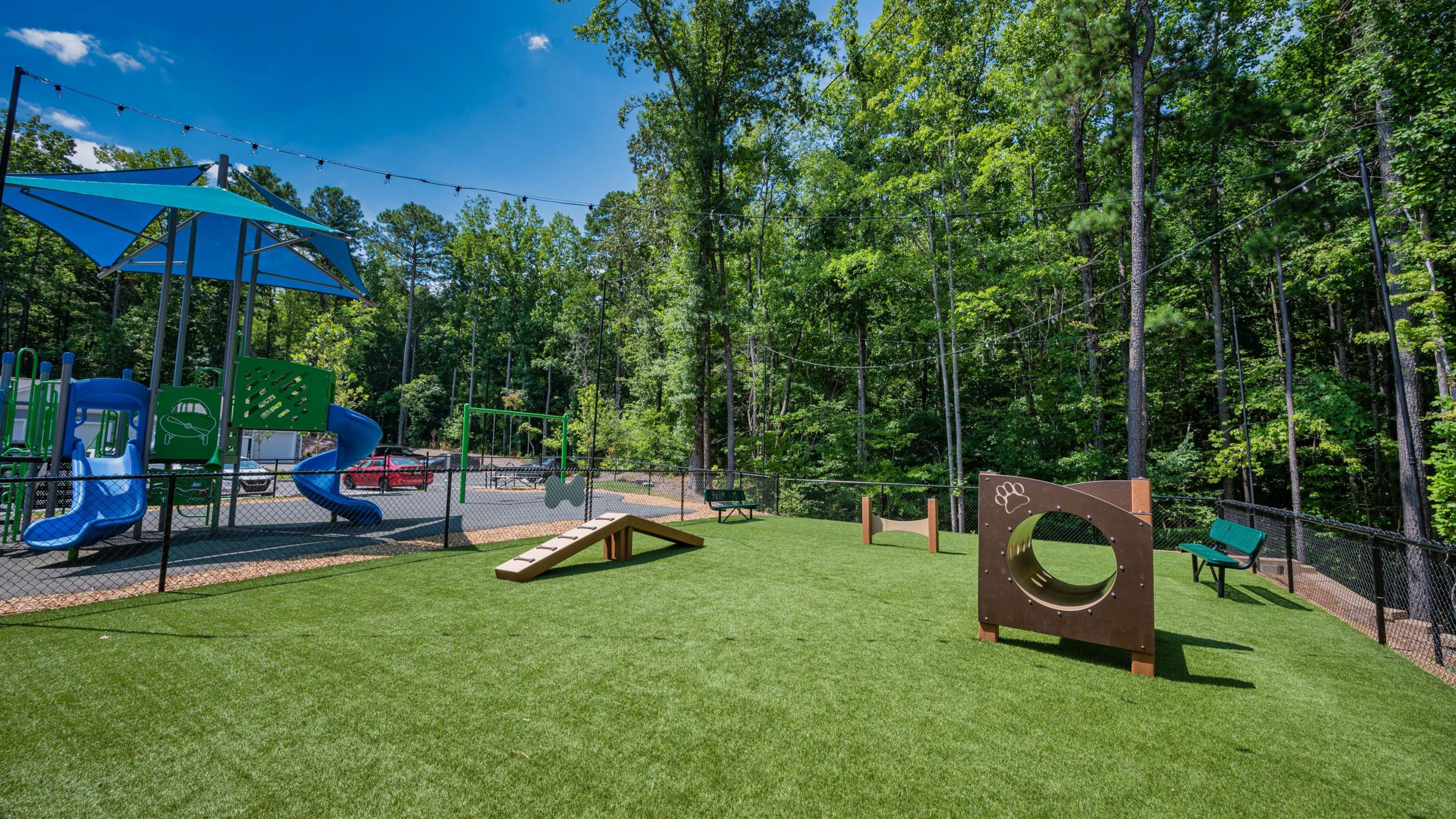 Hawthorne at Parkside outdoor area with large playground next to a dog park with agility equipment